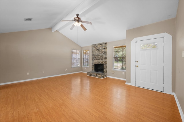 unfurnished living room featuring a fireplace, lofted ceiling with beams, light hardwood / wood-style floors, and ceiling fan