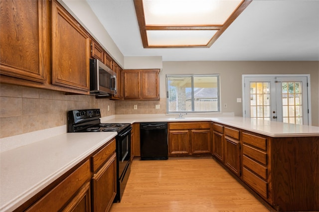 kitchen with french doors, black appliances, decorative backsplash, light wood-type flooring, and kitchen peninsula