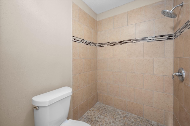 bathroom with toilet and a tile shower