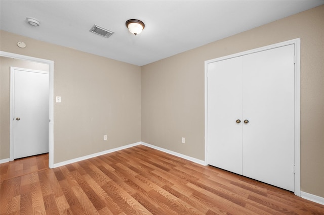 unfurnished bedroom featuring a closet and light hardwood / wood-style floors