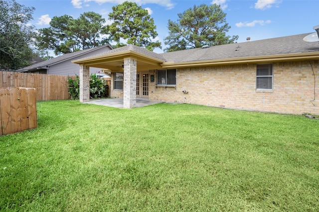 back of house featuring a yard, a patio, and french doors