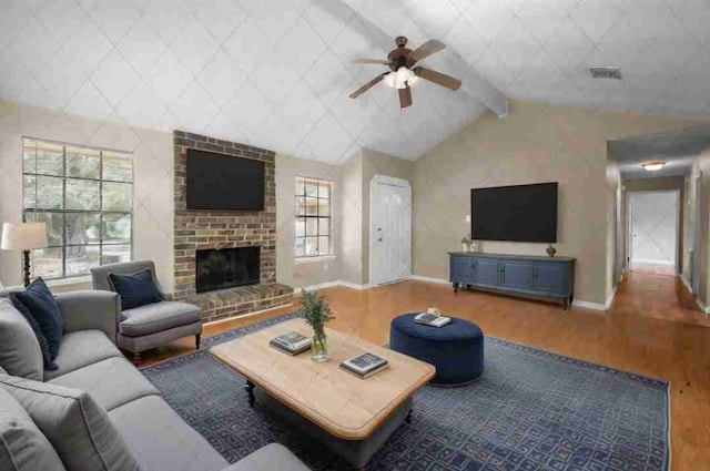 living room featuring a fireplace, wood-type flooring, lofted ceiling with beams, and ceiling fan