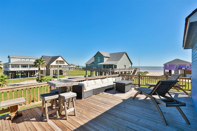 wooden deck with an outdoor living space and a water view