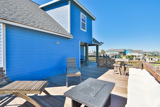 wooden deck featuring an outdoor living space with a fire pit