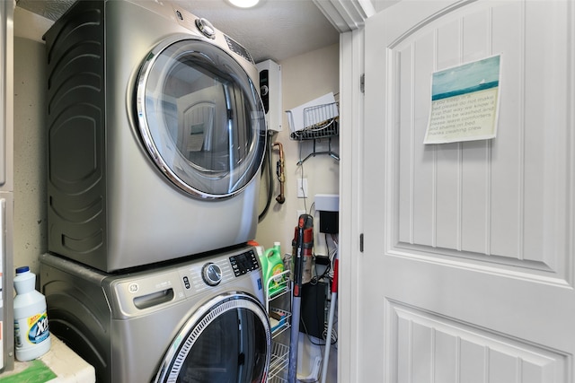 laundry room with a textured ceiling and stacked washer and dryer