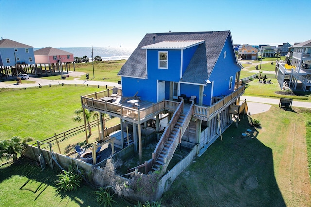 rear view of house with a wooden deck and a yard