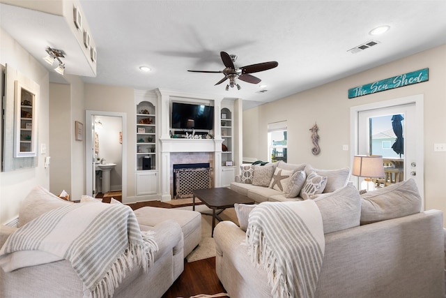 living room featuring dark hardwood / wood-style floors, built in features, and ceiling fan