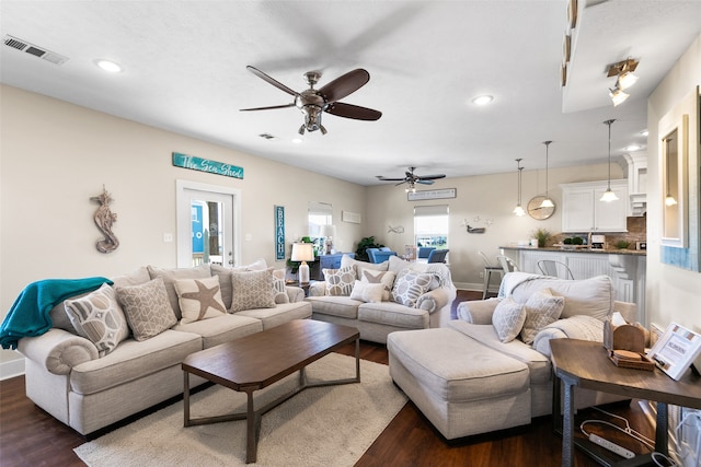 living room with ceiling fan and dark wood-type flooring