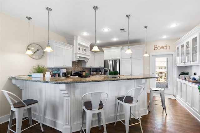 kitchen featuring stainless steel fridge, white cabinetry, decorative light fixtures, and black range with electric cooktop