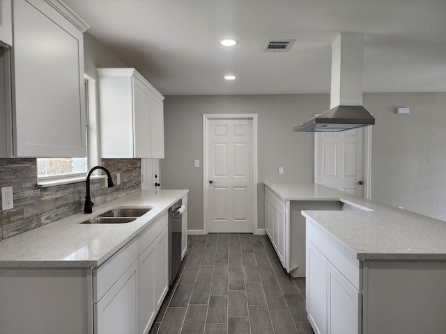 kitchen featuring white cabinetry, island range hood, sink, and backsplash