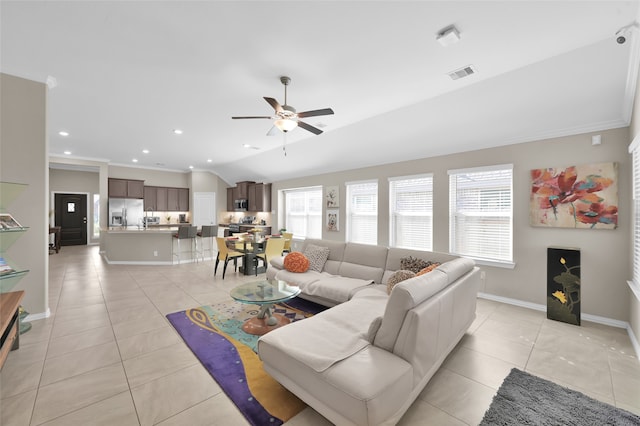 living room with ceiling fan, crown molding, light tile patterned floors, and vaulted ceiling