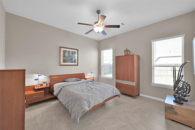 bedroom featuring multiple windows, light tile patterned floors, and ceiling fan