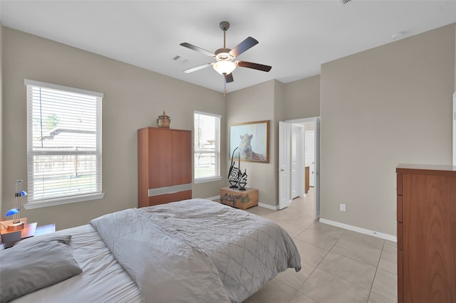 bedroom featuring ceiling fan, light tile patterned flooring, and multiple windows