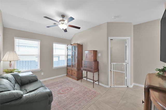 living room with vaulted ceiling, ceiling fan, and light tile patterned flooring