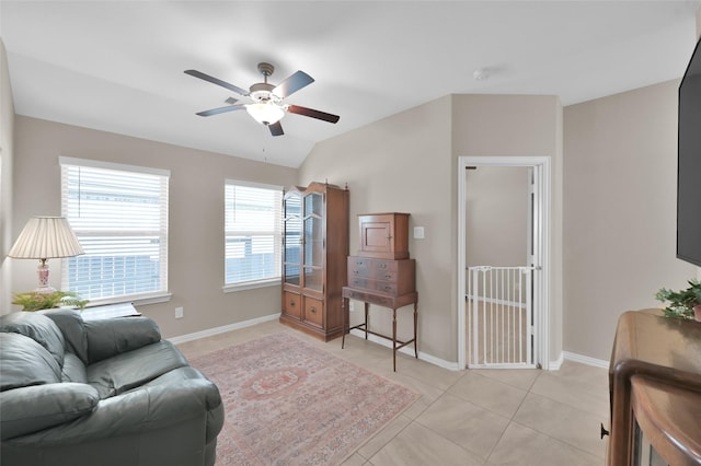 living room with ceiling fan, lofted ceiling, and light tile patterned floors