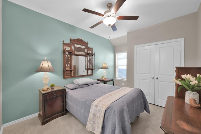 bedroom featuring light tile patterned flooring, lofted ceiling, ceiling fan, and a closet