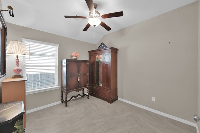 sitting room with ceiling fan, light tile patterned flooring, and lofted ceiling