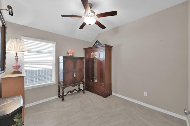 living area featuring light tile patterned flooring, ceiling fan, and vaulted ceiling