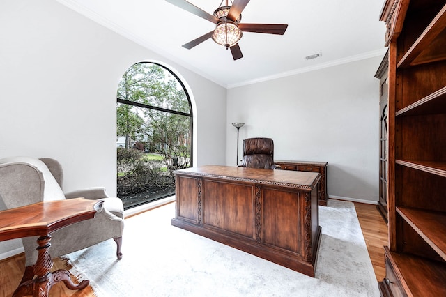 home office featuring light wood-type flooring, ceiling fan, and ornamental molding