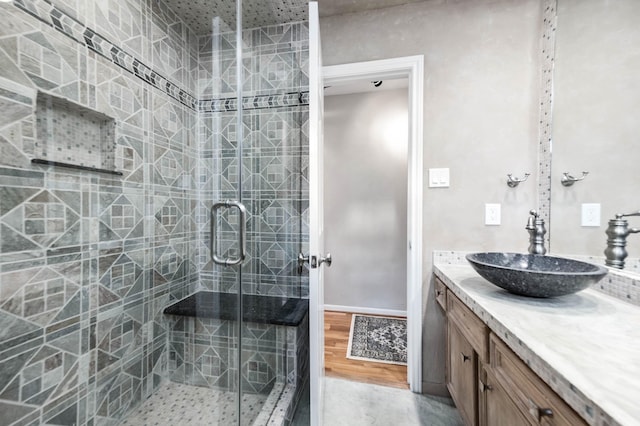 bathroom with a shower with door and vanity