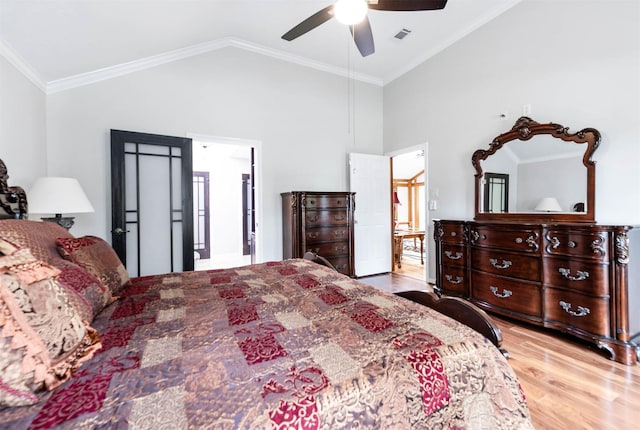 bedroom featuring ceiling fan, light hardwood / wood-style flooring, crown molding, and vaulted ceiling