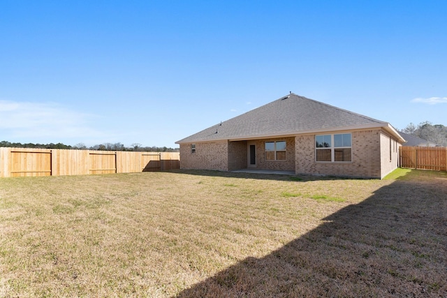 rear view of property featuring a yard