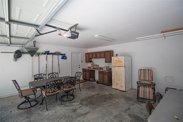 garage featuring white fridge and a garage door opener