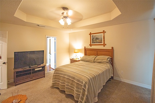 bedroom featuring carpet, ceiling fan, and a tray ceiling