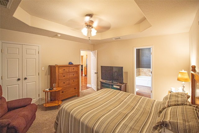 bedroom featuring carpet flooring, a raised ceiling, ceiling fan, and a closet