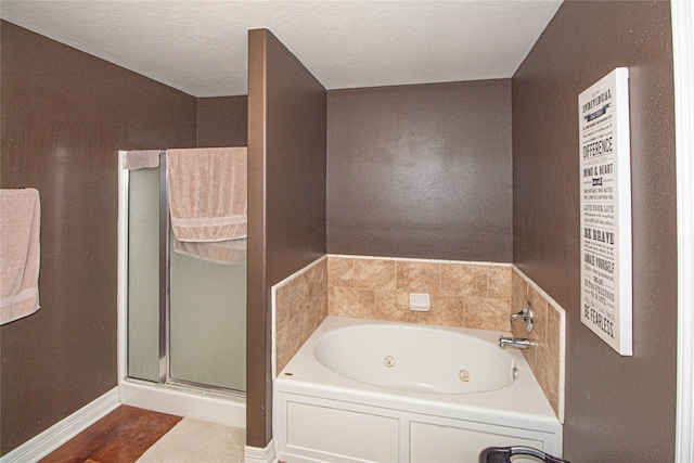 bathroom featuring a textured ceiling and plus walk in shower