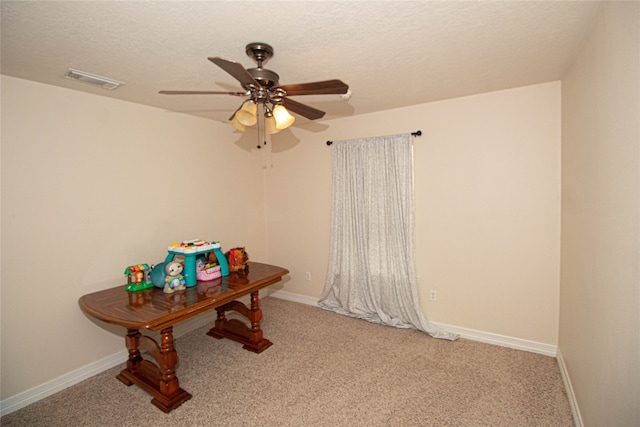 unfurnished office with ceiling fan, carpet, and a textured ceiling