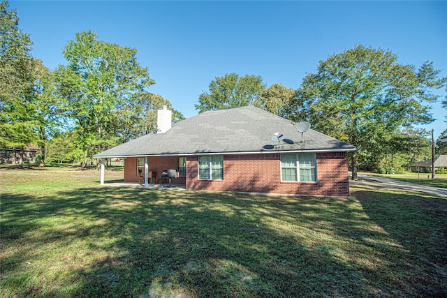 rear view of house with a patio area and a yard