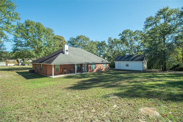 view of yard featuring central air condition unit, a patio area, and an outdoor structure