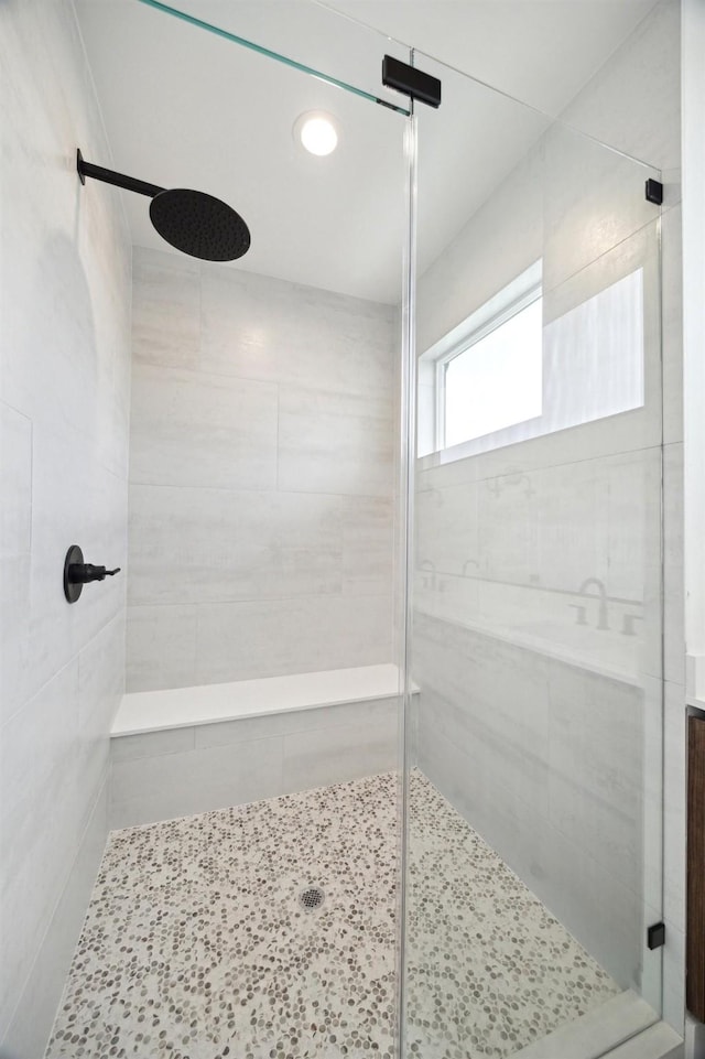 bathroom with a shower with door