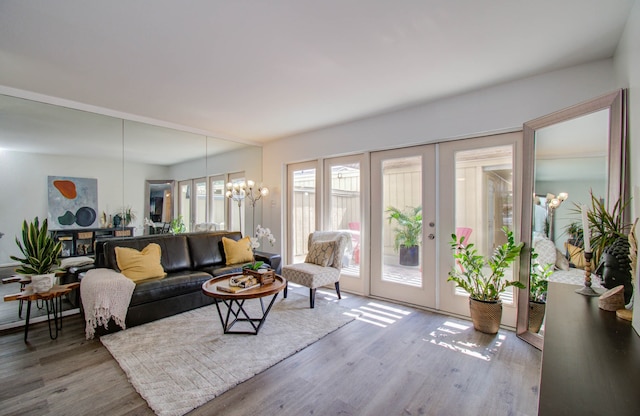 living room with french doors, wood-type flooring, and a notable chandelier