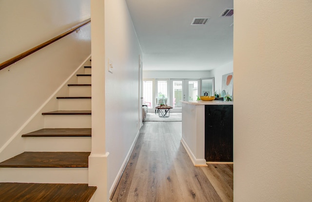 staircase with hardwood / wood-style floors