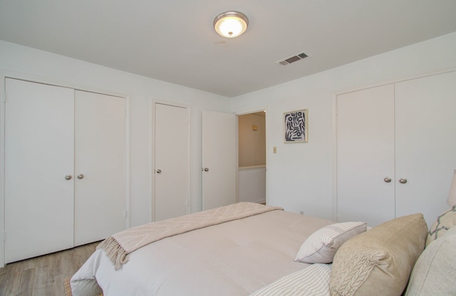 bedroom featuring two closets and light wood-type flooring