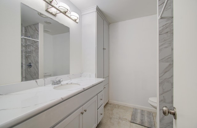 bathroom with tile patterned flooring, a tile shower, vanity, and toilet