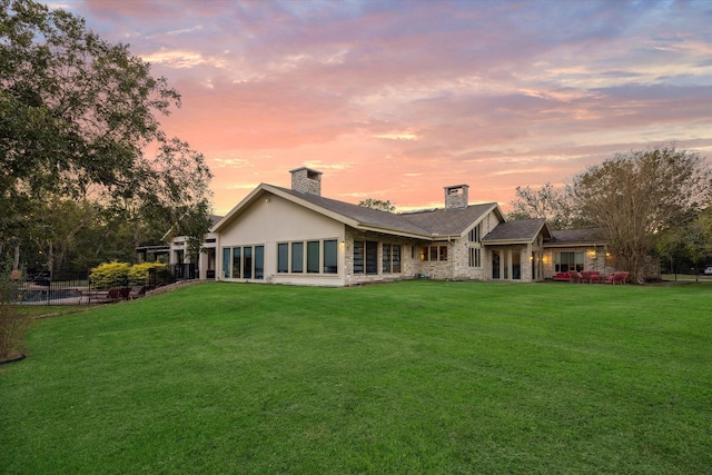 rear view of property featuring a yard and a chimney