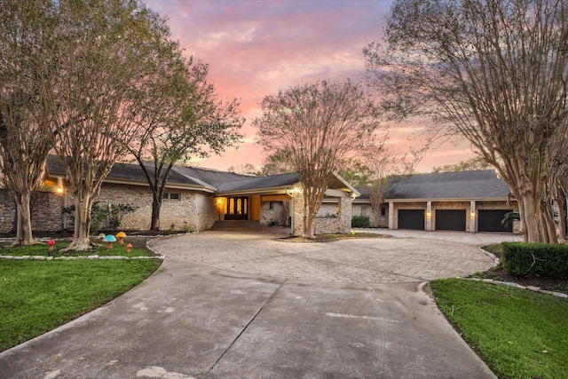 view of front of property featuring a front lawn, driveway, and an attached garage