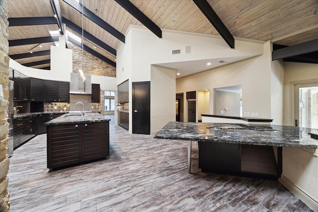 kitchen featuring plenty of natural light, a sink, beamed ceiling, and wood finished floors