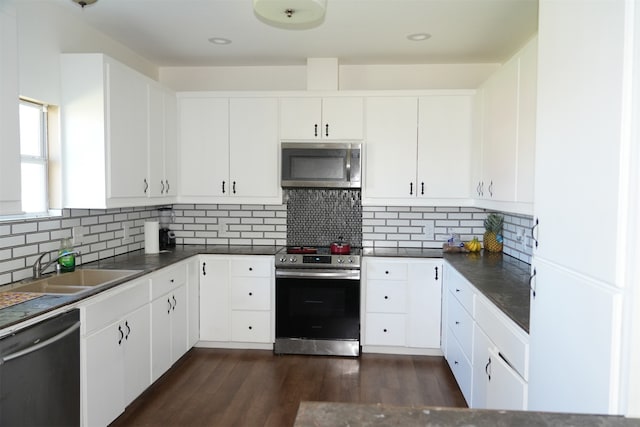 kitchen featuring white cabinetry, sink, tasteful backsplash, dark hardwood / wood-style floors, and appliances with stainless steel finishes