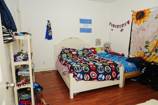 bedroom with dark hardwood / wood-style flooring