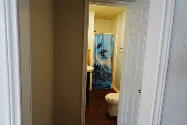 bathroom featuring hardwood / wood-style flooring, toilet, and walk in shower