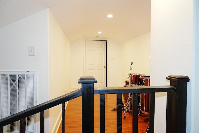 hall with vaulted ceiling and hardwood / wood-style flooring