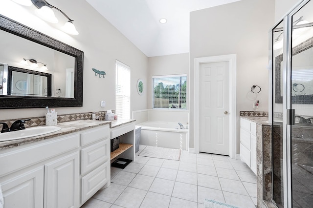 bathroom with tile patterned flooring, vanity, vaulted ceiling, and shower with separate bathtub