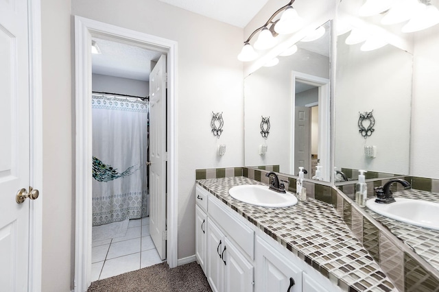 bathroom with tile patterned floors, vanity, a textured ceiling, and walk in shower