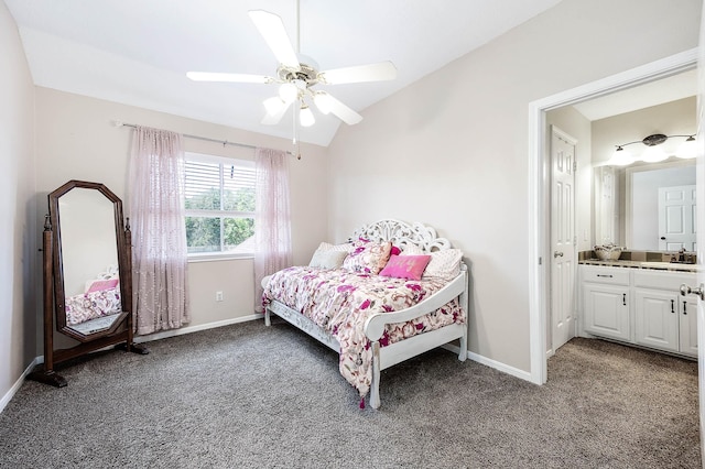 bedroom featuring ensuite bath, ceiling fan, dark carpet, and vaulted ceiling