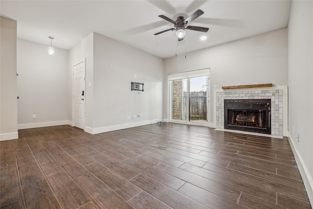 unfurnished living room with dark hardwood / wood-style floors, ceiling fan, and a brick fireplace