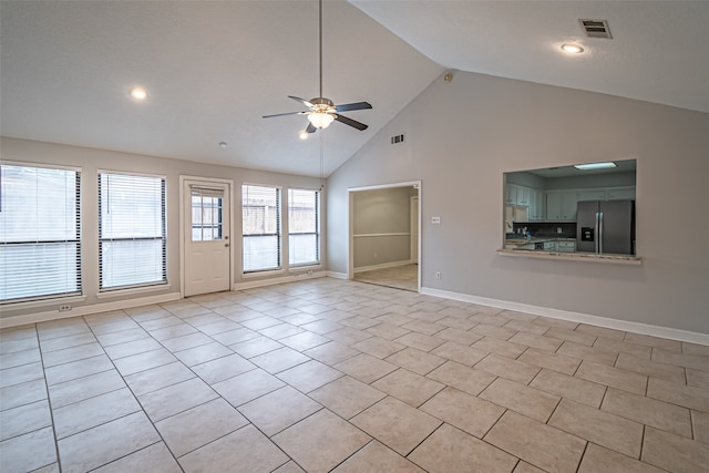 unfurnished living room with ceiling fan, light tile patterned floors, and high vaulted ceiling